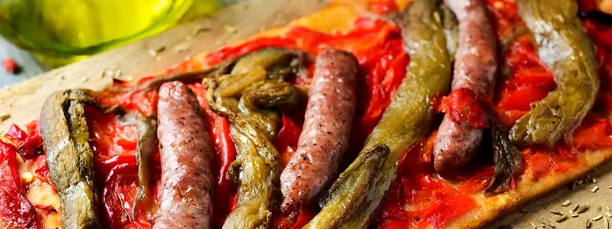 Coca de verduras y salchichas gratinadas